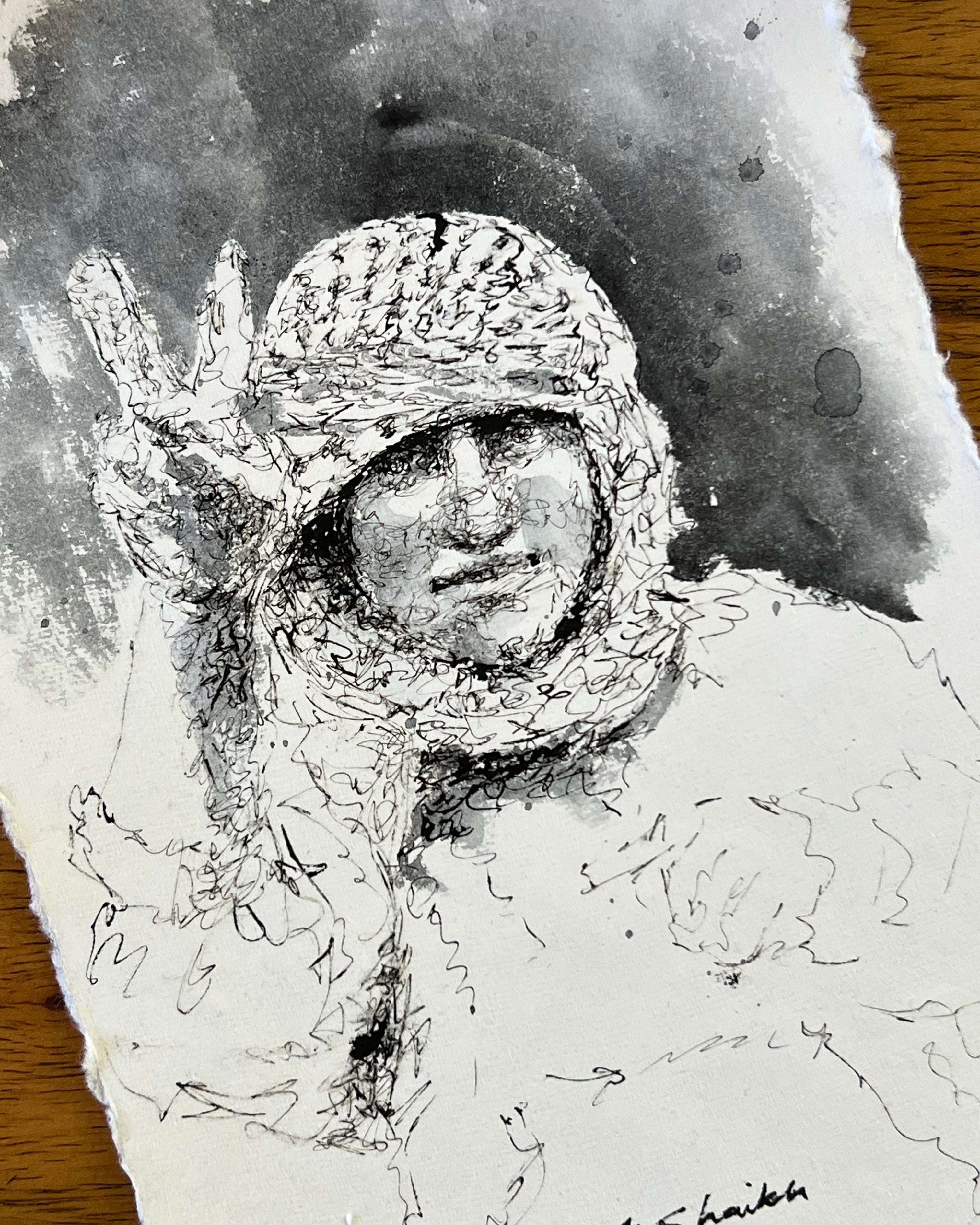 A black and white charcoal or ink sketch of a person wearing a knit hat, rendered on torn white paper with dark smoky washes, photographed on a wooden surface.